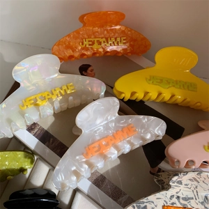 Colorful acetate claw clips with J'AIME lettering in various fashion patterns