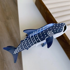 Vue détaillée d'une pince à cheveux requin-baleine bleue en acétate avec motifs blancs