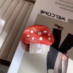 Detailed view of red mushroom hair claw clip made of acetic acid plate material