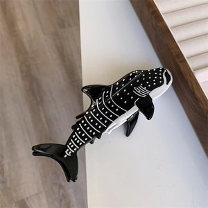 Vue détaillée de dessus d'une pince à cheveux requin-baleine en acétate noir et blanc
