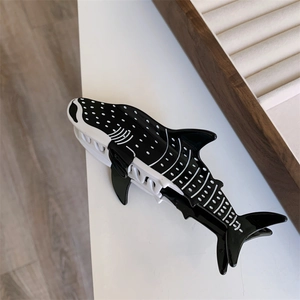 Vue détaillée de la pince à cheveux en acétate en forme de baleine avec motifs noirs et blancs