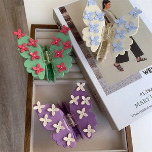 Détail de pinces à cheveux élégantes en acétate avec fleurs 3D et accents de strass brillants