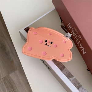 Detail von rosa Käse Haarklammer mit Comic-Gesicht und Bär auf einer Geschenkbox