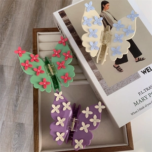 Vue détaillée de grandes pinces à cheveux papillon avec fleurs 3D aux couleurs pastel