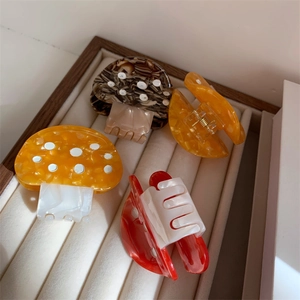Detailed view of colorful mushroom-shaped acetate hair claws with marbled textures