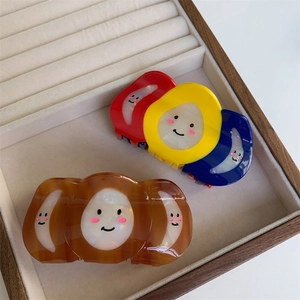 Détail de pinces à cheveux en résine tricolores et ambre avec motifs smiley mignons