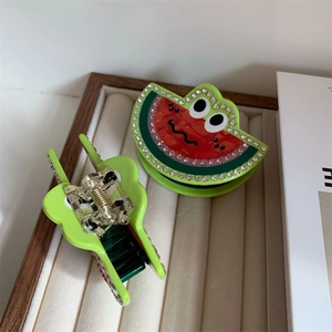 Dettaglio del fermaglio a forma di anguria con strass lucidi e finitura in acetato