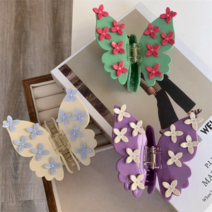 Trois pinces à cheveux papillon colorées avec fleurs 3D et détails en strass
