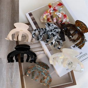 Detail showing various acetate hair claws with premium France Handmade engraving