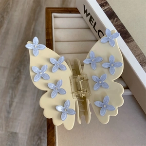Détail macro d'une pince à cheveux papillon avec fleurs bleu pâle et petits strass
