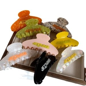 Set of seven colorful acetate hair claws with Je T'aime lettering in various vibrant colors