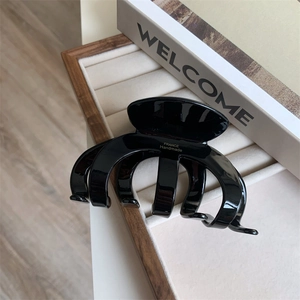 Close-up of black glossy acetate hair claw with gold France Handmade lettering