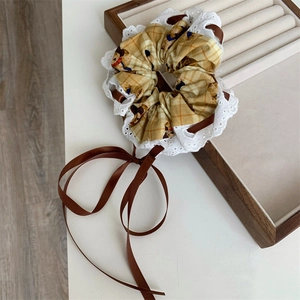 Japanese style yellow plaid scrunchie with lace edges and a long brown ribbon bow