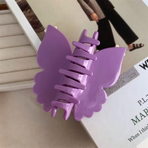 Vue détaillée d'une grande pince à cheveux papillon violette avec finition brillante