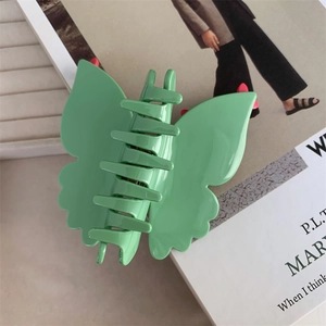 Détail de la grande pince à cheveux papillon vert clair en acétate avec finition brillante