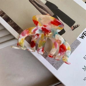 Detail view of large acetate claw clip with colorful oil painting marble texture