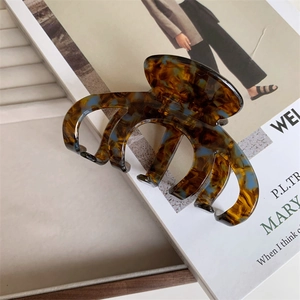 Close-up of large tortoiseshell acetate hair claw clip with blue marble patterns