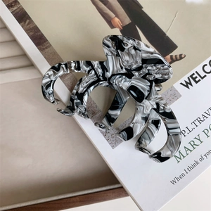 Detail of large acetate hair claw clip featuring black and white marble ink texture