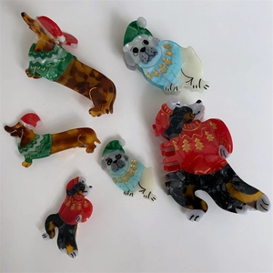 Close-up of dog hair clips in Christmas sweaters made of acetate for holiday styling