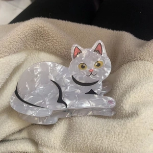 Gros plan sur la pince à cheveux chat en acrylique blanc avec texture nacrée