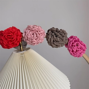 Close-up of handmade fabric rose hair claws in red, pink, brown, and rose colors