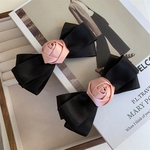 Elegant set of two black satin bow hair clips with soft pink silk rose accents