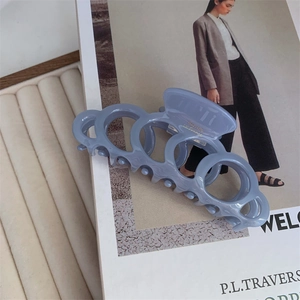 Detail of matte blue acetate hair claw clip featuring golden Barrette La France text