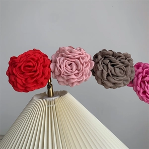 Detail of handmade 3D fabric rose hair clips in vibrant pink and red floral designs