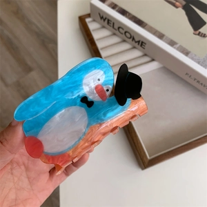 Detailed view of the cute penguin hair claw clip with marble texture and tuxedo design