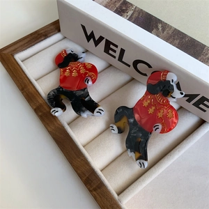 Detail of dachshund hair clips with red Christmas sweaters and gold tree embossing
