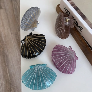 Detailed set of colorful shell-shaped hair claws with glitter finish and rhinestone accents