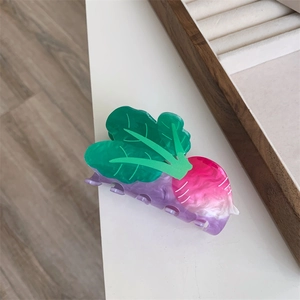 Close-up of a gradient radish hair claw clip with green leaves and acetic acid texture