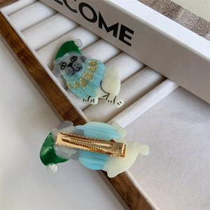 Detail of the cute pug hair clip showing acetate material and golden metal alligator grip