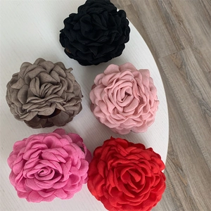 Detailed flat lay of large fabric rose hair claws in black, pink, and red colors