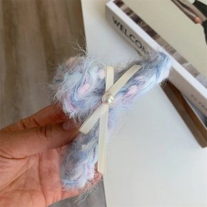 Detail van de blauw-roze pluche haarklem met zijden strik en parelaccent voor dames