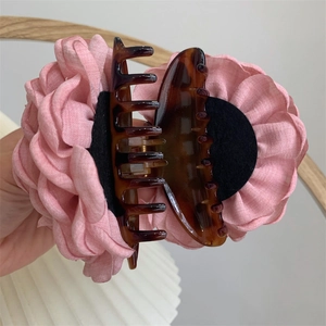 Detail of pink fabric flower hair claw clip with tortoiseshell pattern base and petals