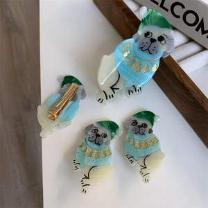 Detail of cute dog hair clip with Christmas sweater pattern and gold alligator clip