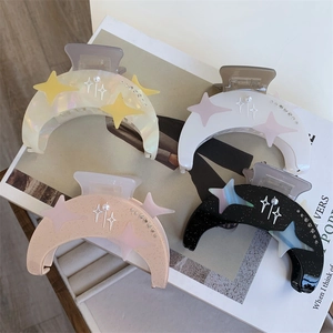 Détail de pinces à cheveux lune en acétate avec perles et étoiles en quatre coloris