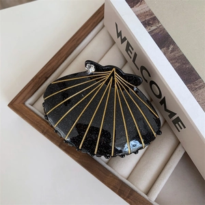 Elegant black shell hair claw clip with gold glitter stripes and a sparkling rhinestone