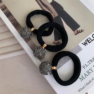 Macro shot of gray rhinestone sphere hair ties on a fashion magazine background