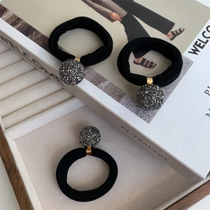 Three-piece set of grey crystal ball elastic hair bands on an elegant jewelry tray