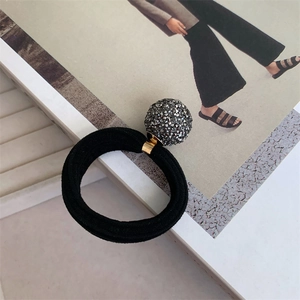 Detailed close-up of a sparkling dark grey rhinestone ball on a black high-elastic hair tie
