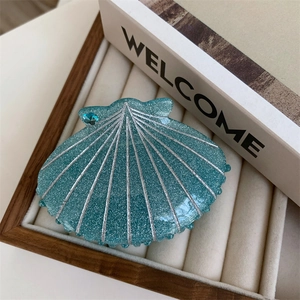 Detailed view of ocean shell hair claw clip in teal with glitter and blue rhinestone
