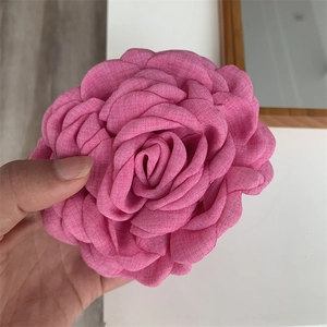 Macro detail of large dried rose hair claw clip in pink textured linen fabric