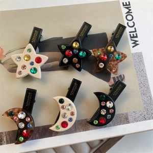 Détail de 6 barrettes cheveux avec strass colorés en forme d'étoile et de lune