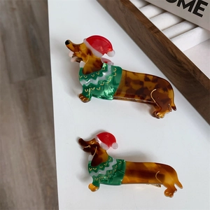 Detail of dachshund hair clips with festive Christmas hats and colorful holiday patterns