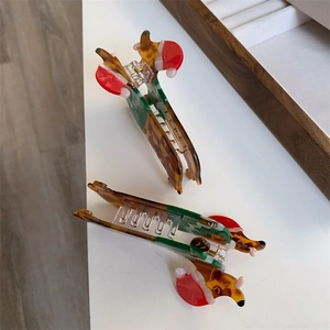 Detail of Christmas dog hair claws featuring acetate reindeer with festive red hats