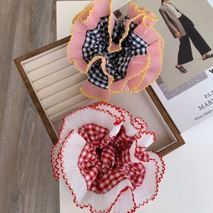 Close-up of pink and white checkered lace hair scrunchies on a wooden display tray