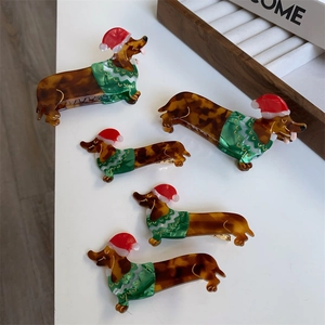 Detail view of five Christmas dachshund hair claws with festive sweater and santa hat design