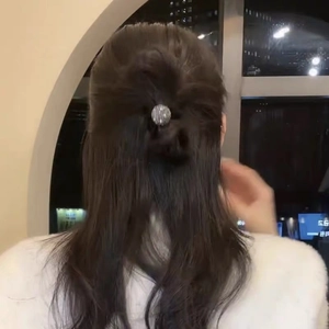 Elegant grey hair scrunchie with sparkling crystal spheres worn by a woman for hair styling